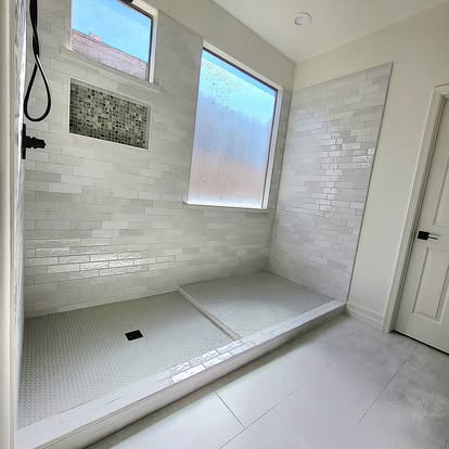 Completed tiled walk-in shower with niche and natural light
